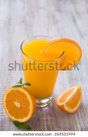 Orange juice in a glass with slice of orange and mint leaves