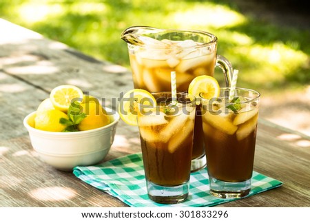 Picnic table in summertime with cold iced tea and lemons