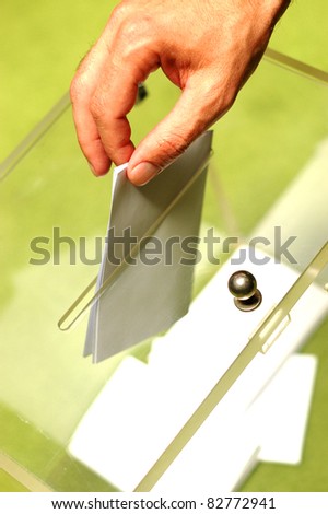 Hand putting a blank ballot inside the box, elections concept