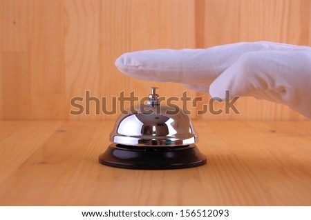 Hand in a white glove ringing the bell to call