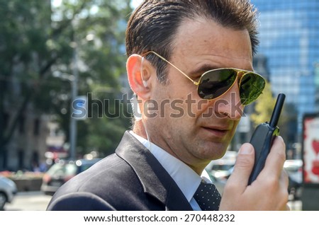 Security guard with glasses and walkie-talkie in his hand, SOFT FOCUS