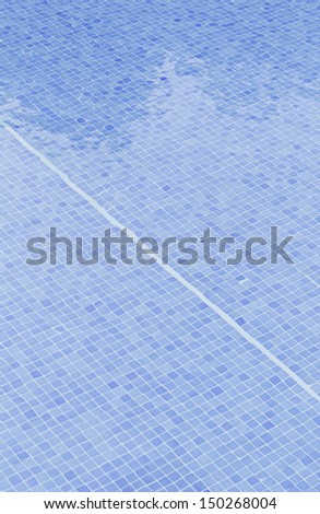 Swimming pool filled with moving water and blue tiles