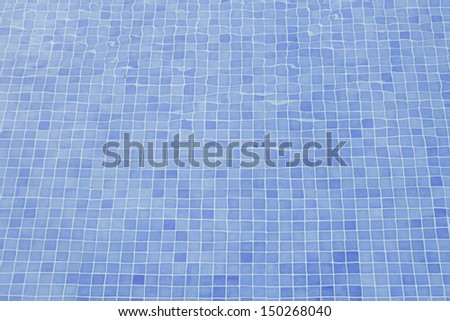Swimming pool filled with moving water and blue tiles