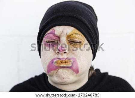 Girl sad clown in urban street, expression