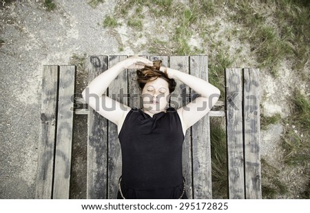 Woman sleeping on wooden table in nature