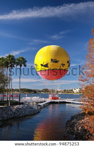 Multicolored balloon moored to landing stage at lake