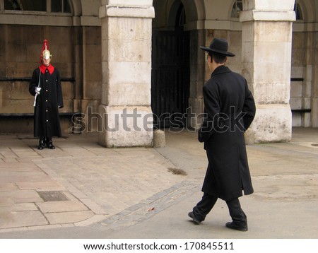 LONDON, UK - MARCH 30, 2006: Two young people - member of the Household Cavalry on duty and jewish orthodox visitor have met in London, UK on March 30, 2006. London is the world\'s most-visited city