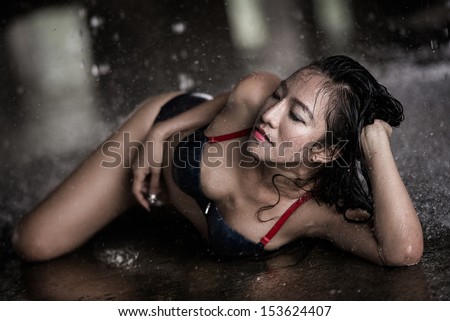 Sexy bikini girl among the rain and water