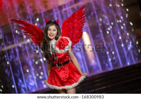 Pretty Asian girl in Santa costume for Christmas with night light