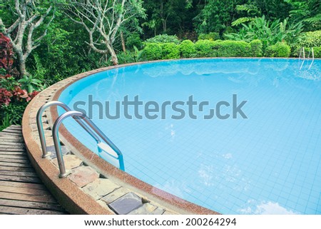 Swimming pool with stair in the green garden