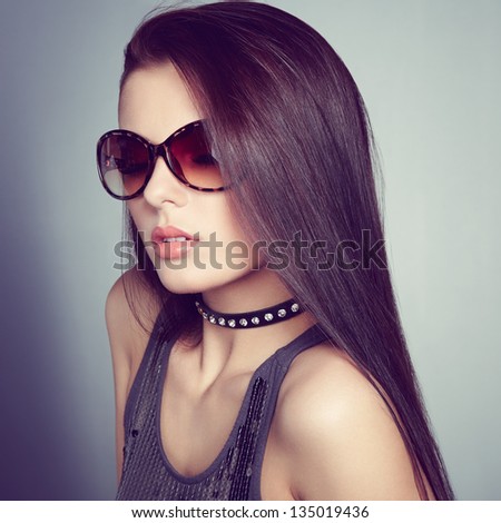 Young beautiful girl in sunglasses. Pretty model poses at studio.