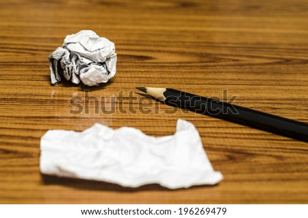 paper scrap and crumpled with pencil on wood background