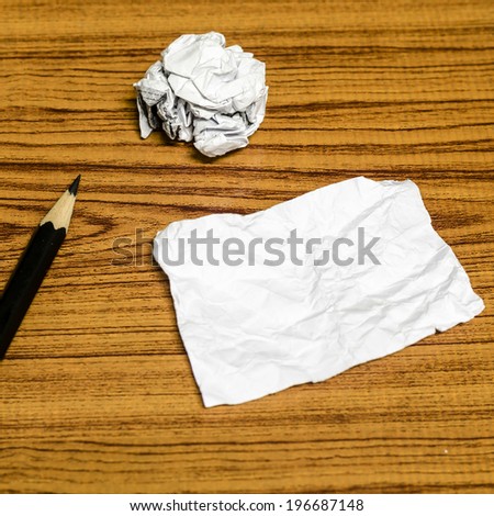 paper scrap and crumpled with pencil on wood background