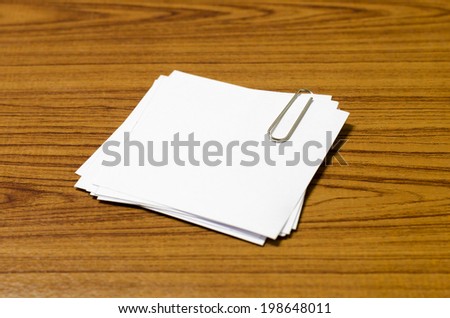 stack of paper with clip on wood background