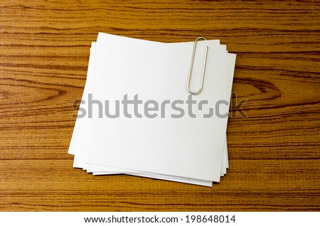 stack of paper with clip on wood background