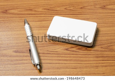 stack of business card with pen on wood background