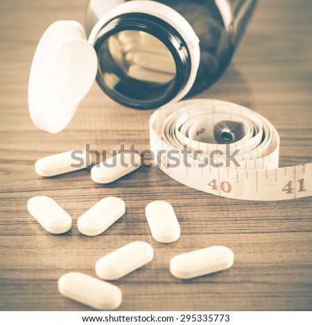 pills and measuring tape concept diet with drug vintage style