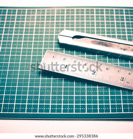 ruler and cutter on green cutting mat vintage style