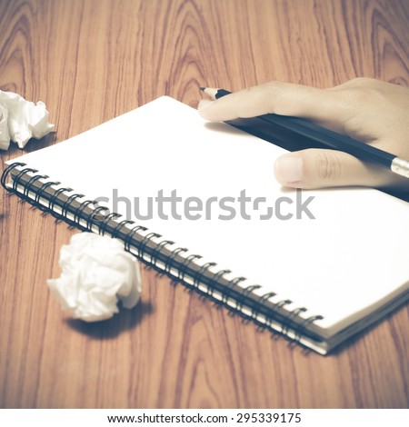 hand writing on notebook with crumpled paper on wood table background vintage style