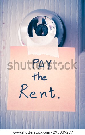 sticky note write a message pay the rent on the latch door vintage style