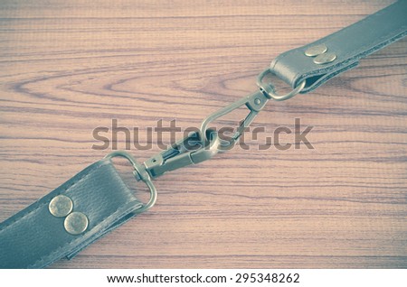 bag leather strap on wood background vintage style
