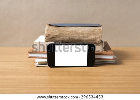 stack of book and smart phone on wood background