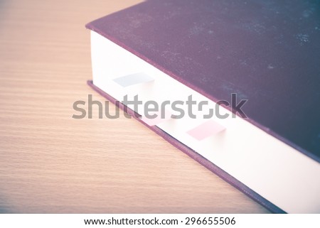 orange book with sticky note on wood background vintage style