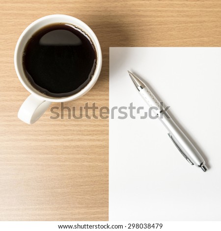 coffee cup with white paper and pen on wood background