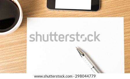 paper and pen with coffee cup and smart phone on wood background