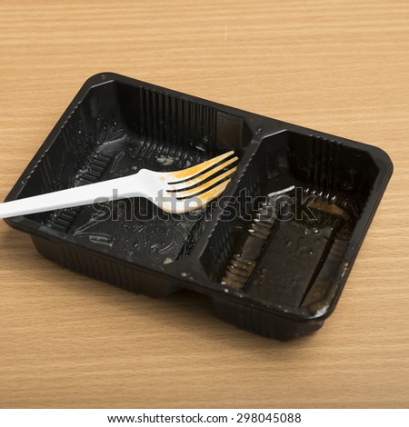 dirty plastic food container on wood background