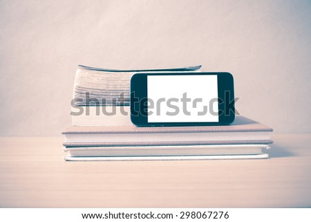 stack of book and smart phone on wood background vintage style