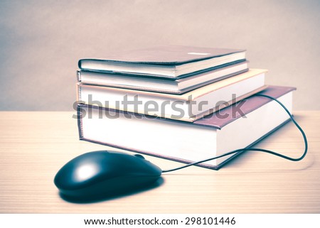 book and computer mouse on wood background vintage style