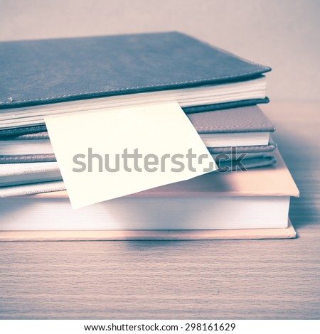 stack of book with sticky note on wood background vintage style
