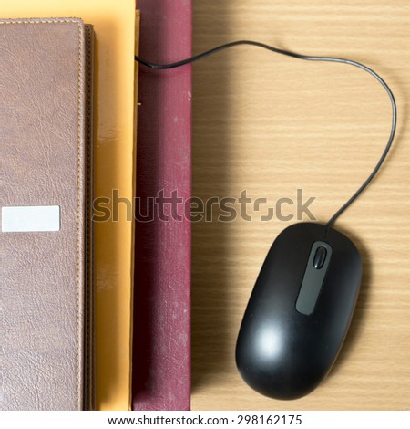 book and computer mouse on wood background