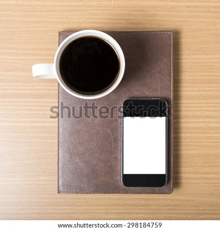 smart phone and coffee cup on book on wood background