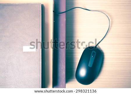 book and computer mouse on wood background vintage style
