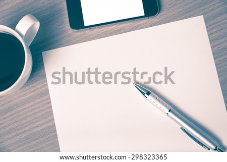 paper and pen with coffee cup and smart phone on wood background vintage style