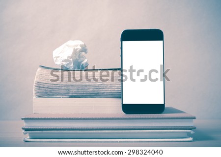 stack of book and smart phone on wood background vintage style