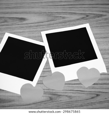 photo frame with heart on wood background black and white color tone style