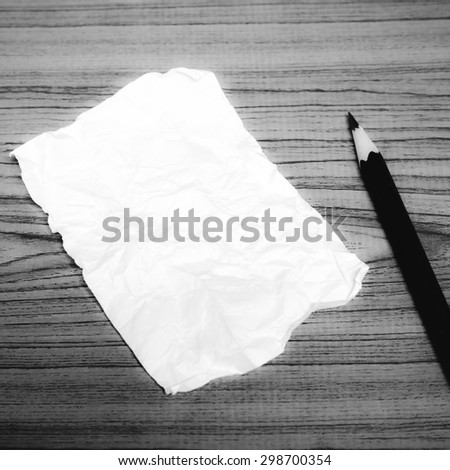 paper scrap with pencil on wood background black and white color tone style