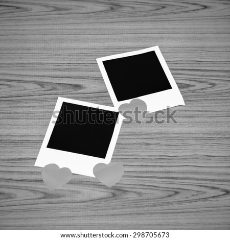 photo frame with heart on wood background black and white color tone style