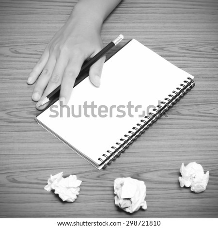 hand writing on notebook with crumpled paper on wood table background black and white color tone style