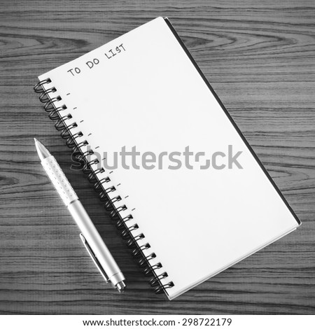notebook and pen with word to do list on wood background black and white color tone style