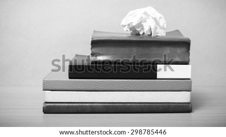 book and crumpled paper on wood background black and white color tone style