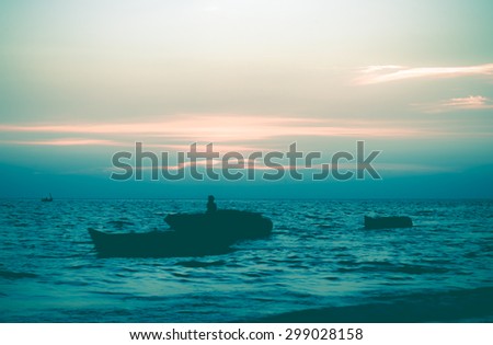 beautiful natural background the sun sets with clounds and black Silhouette boat on sea blurry vintage style