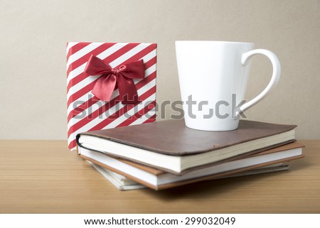 book with gift box and coffee mug on wood background
