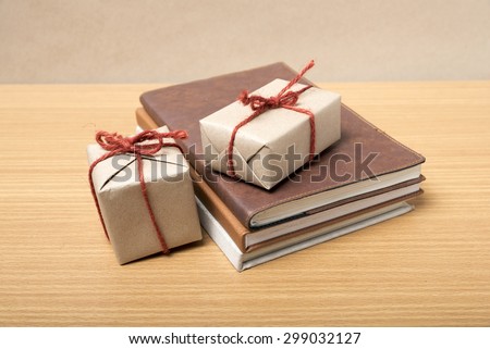 book with gift box on wood background