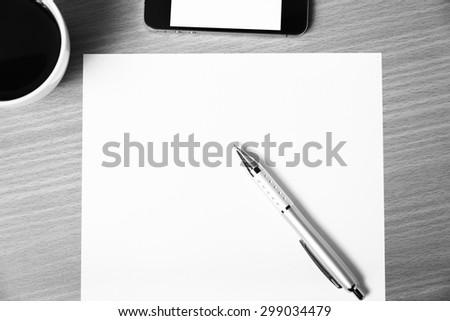 paper and pen with coffee cup and smart phone on wood background black and white color tone style