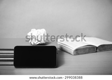 stack of book with smart phone on wood background black and white color tone style