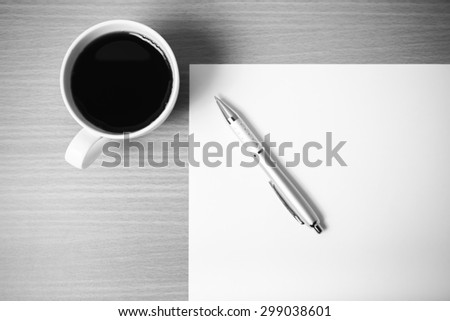 coffee cup with white paper and pen on wood background black and white color tone style